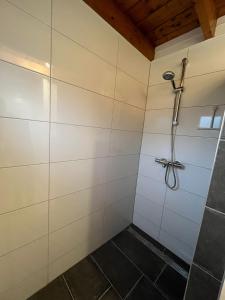 埃尔默洛Veluwse Bungalow的浴室铺有白色瓷砖,设有淋浴。