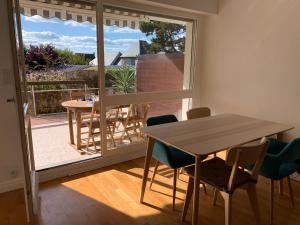 滨海图维列Trouville, appartement rénové avec grande terrasse au calme的一间带桌椅的用餐室和一个阳台