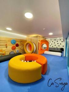 危地马拉CaSuya Airali apartments with heated pool, gym in city center的一间儿童间,配有黄色和橙色的长软椅