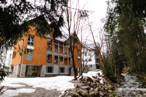 哈拉霍夫90 m2 horský apartmán v centru Harrachova的一座橙色的建筑,地面上积雪