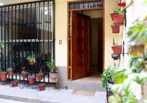 库斯科Zans Apartments Cusco的一道开敞的门,里面装有盆栽植物