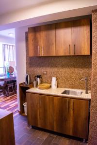 库斯科Zans Apartments Cusco的一个带木制橱柜和水槽的厨房