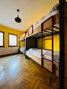 普里什蒂纳Hostel Prishtina Backpackers的黄色墙壁的客房内设有两张双层床。