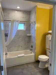 太平洋丛林太平洋丛林海风宾馆的浴室配有白色浴缸和卫生间。