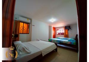 巴兰基亚Hotel Nueva Esperanza的一间卧室设有两张床和窗户。