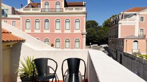 里斯本希阿杜茉莉花酒店的大楼前阳台配有2把黑色椅子