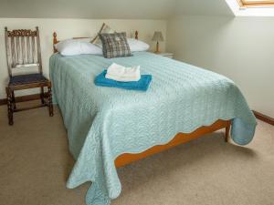 MintlawMiddle Lodge的一间卧室配有一张带蓝色毯子和椅子的床
