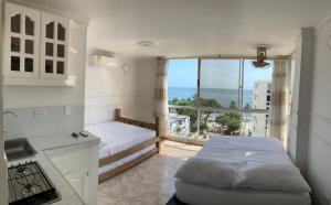 圣玛尔塔Luna Azul Rodadero apartaestudios的一间卧室设有一张床和一个美景阳台
