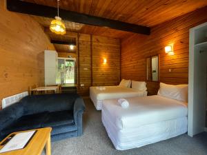 罗托鲁瓦Lakes Lodge Okataina的酒店客房,设有两张床和一张沙发
