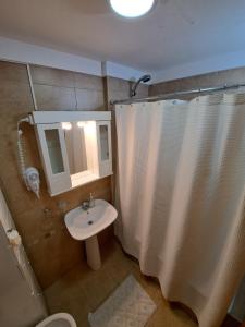 巴拉那Paraná Confort的浴室设有白色的淋浴帘和水槽