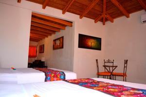 科利马阿尔达马酒店的一间卧室配有两张床和一张桌子及椅子