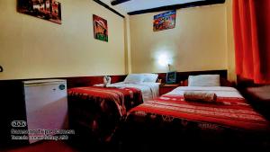 库斯科Hostal sambleño cusco Piero suite的酒店客房,配有两张带红色床单的床