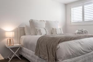 奥克兰Stay Coastal - Mission Bay的白色卧室配有一张带白色枕头的大床
