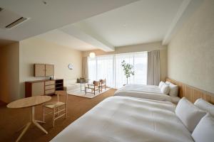 松山Hotel Lepo Chahal的酒店客房配有两张床和一张书桌