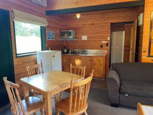 罗托鲁瓦Lakes Lodge Okataina的厨房以及带桌子和沙发的用餐室。
