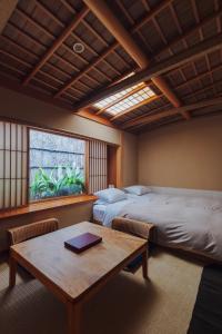 京都元奈古旅馆的客房设有两张床、一张桌子和一扇窗户。