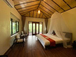 Bắc YênTa Xua Ecolodge的一间卧室配有一张带蚊帐的床