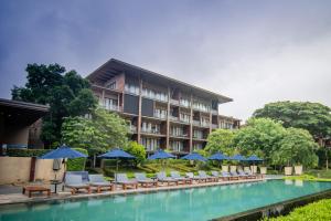Pak ChongKhaoyai Luxury Pool Penthouse at ATTA的游泳池旁的酒店拥有椅子和遮阳伞
