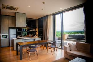 Pak ChongKhaoyai Luxury Pool Penthouse at ATTA的厨房以及带桌椅的起居室。