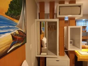 纳塔尔Ilusion Flats Aconchego de Ponta Negra的浴室设有镜子和墙上的绘画作品