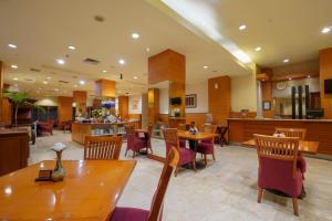 泗水Hotel Bisanta Bidakara Tunjungan的一间带桌椅的餐厅和一间酒吧