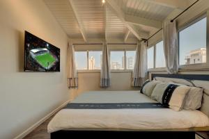 拉马特甘LUXURY PENTHOUSE GREAT LOCATION WITH PARKING Tlv的一间卧室配有一张床,享有棒球比赛的景色