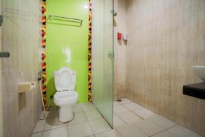纳闽巴霍RedDoorz near Pantai Pede的浴室配有卫生间、淋浴和盥洗盆。