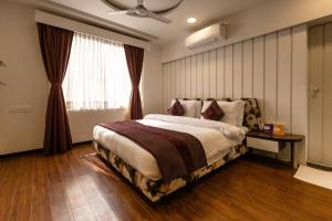 艾哈迈达巴德3 BY OYO Nami Residency Ahmedabad的一间卧室设有一张大床和一个窗户。