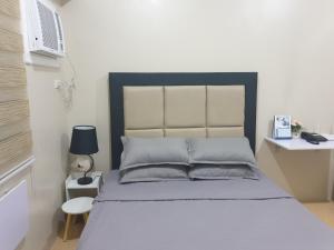 宿务CunduNiAia Sunvida Tower Condominium Unit Across SM Cebu的一间卧室配有一张床和一张带台灯的书桌