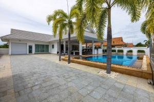 华欣Private 3 Bedroom Pool Villa PP10的一座带游泳池和棕榈树的房子