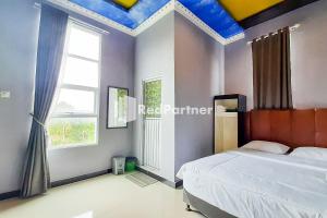 PondokpematangtanahMT Syariah Homestay Kerinci RedPartner的一间卧室设有一张床和蓝色的天花板