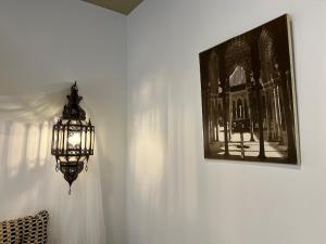 格拉纳达Sueños de la Alhambra的挂在墙上的吊灯,挂着一张照片