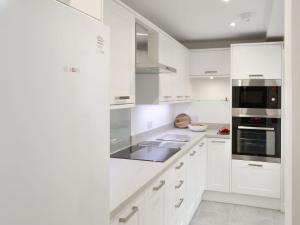 莫珀斯Drovers的白色的厨房配有白色橱柜和电器