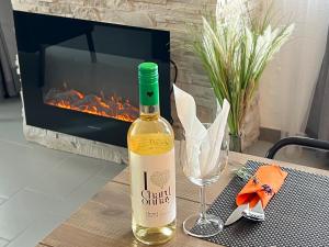 福维莱尔斯Le Clos fleuri的一瓶葡萄酒和一杯放在餐桌上的壁炉