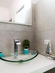 卡布拉斯Kolossoi Guest House的一间带玻璃水槽和镜子的浴室