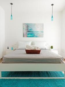卡布拉斯Kolossoi Guest House的白色卧室配有一张蓝色地毯的床