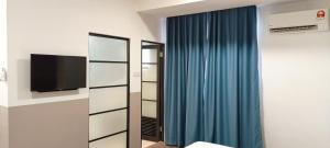 SimanggangRoxy Hotel Sri Aman的一间带镜子和蓝色窗帘的卧室