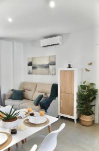 格拉纳达SANTA MARÍA APARTMENT Precioso apartamento en el centro de Granada - Parking gratuito的客厅配有桌子和沙发