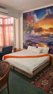 耶路撒冷耶路撒冷全景酒店 的卧室配有一张大床,墙上挂有绘画作品