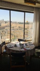 耶路撒冷耶路撒冷全景酒店 的一张桌子,位于一个设有大窗户的房间