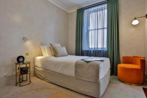 阿米代尔Tattersalls Hotel的一间卧室设有一张床、一个窗口和一把椅子
