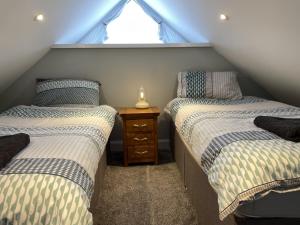 牛顿斯图尔特Galloway Farmstay Claunch的阁楼卧室设有两张床和窗户。
