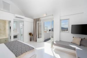 费拉Cycladic Suites的白色的客房设有沙发和电视。