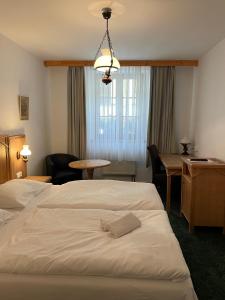 克拉托维Hotel Ennius的配有一张床、一张桌子和一张桌子的酒店客房