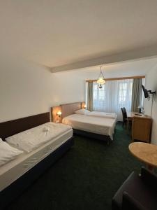 克拉托维Hotel Ennius的酒店客房设有两张床和一张桌子。