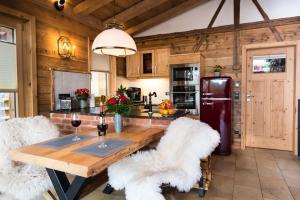 茨维泽尔Bayerischer Wald Chalets的厨房配有木桌和白色椅子