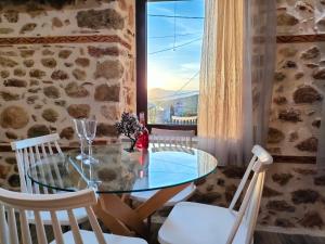 卡兰巴卡Dream Nest Meteora的一间设有玻璃桌和白色椅子的用餐室