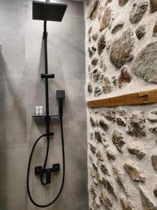 卡兰巴卡Dream Nest Meteora的带淋浴的浴室(带石墙)