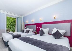 巴黎HOTEL DE PARIS MONTPARNASSE的酒店客房设有两张床和窗户。