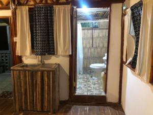 MbwamajiZIONZURI ARTS ECOVILAGE TREE HOUSE的通往带卫生间和门道的浴室的入口